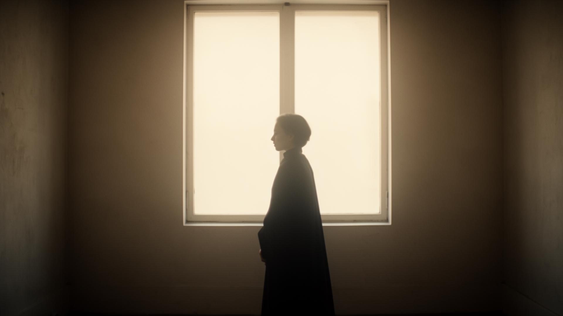 A silhouette of a figure in soft profile against a bright window.